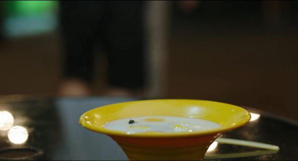 苍蝇落入乳白色的甜品里。