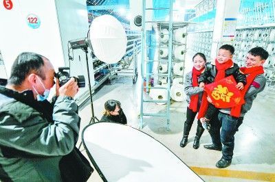 浙江省湖州市一个纺织工家庭拍摄全家福，准备寄回老家。新华社发