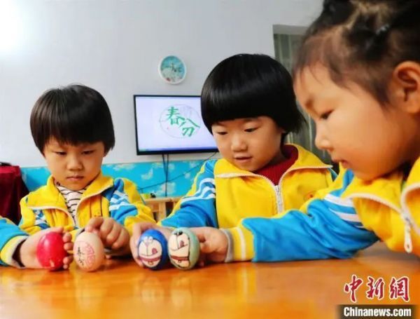 资料图:河北平乡县直第一幼儿园的孩子们玩起“立蛋”游戏,感受春分的文化情趣。姚友谅 摄