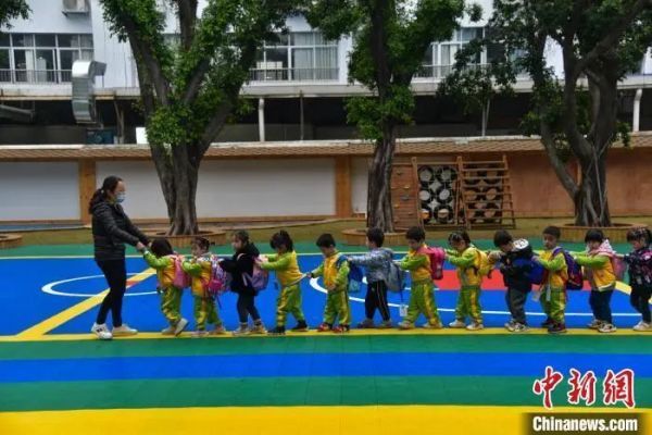 资料图:学生搭着同学跟老师回教室。王以照 摄