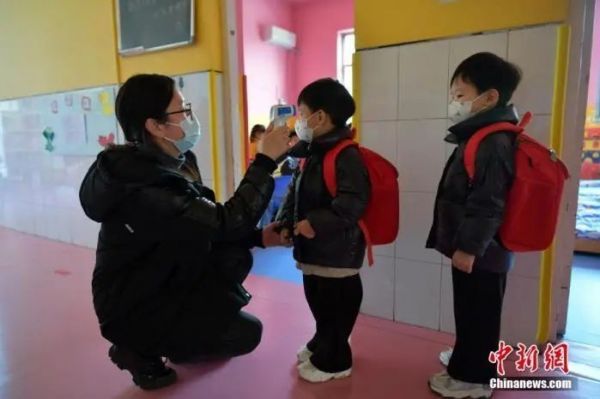 资料图:河北石家庄市某幼儿园,老师为小朋友测量体温。中新社记者 翟羽佳 摄