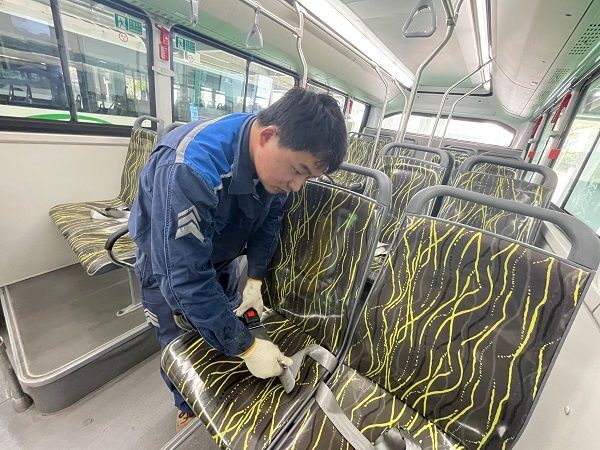 图说:修理工正对乘客座位上的安全带进行安装和装后“体检”