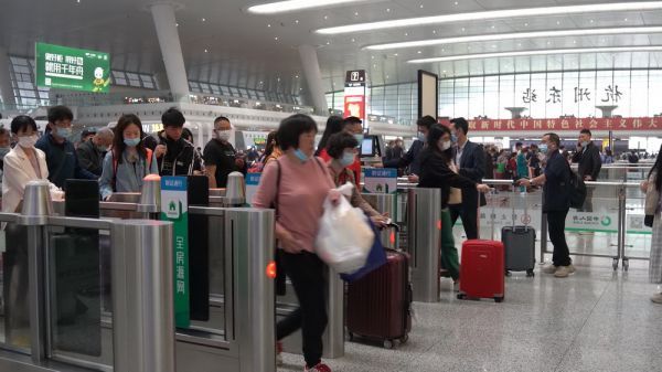 杭州东站候车大厅内,旅客在有序检票进站。