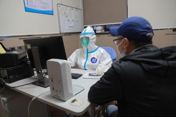 图说:在中山医院发热门诊,值班医生询问患者病情 朱依 摄