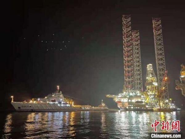 “国信”号石油钻探平台被拖离码头。 王胤 摄