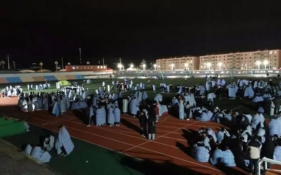 ▲5月22日凌晨,在青海省果洛藏族自治州州府玛沁县,果洛州民族高级中学的学生在操场避险。图片来源:新华社。
