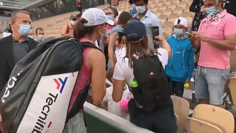 斯瓦泰克签名拍照后不忘把笔还给小男孩