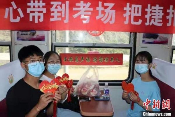 高考考生手持高考祝福卡和心愿荷包在车厢内拍照留念。 强科 摄