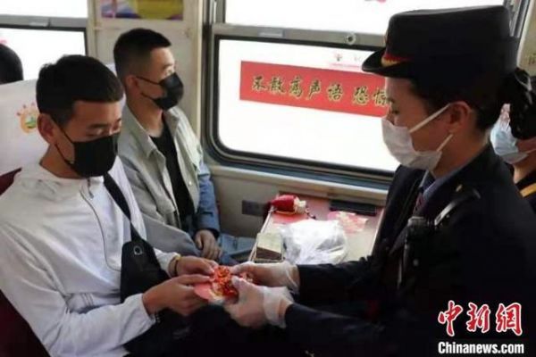 列车工作人员为考生送上高考祝福卡。 关杰 摄