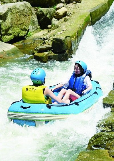 青年游客在浙江安吉山川乡仙龙峡景区体验漂流。新华社发