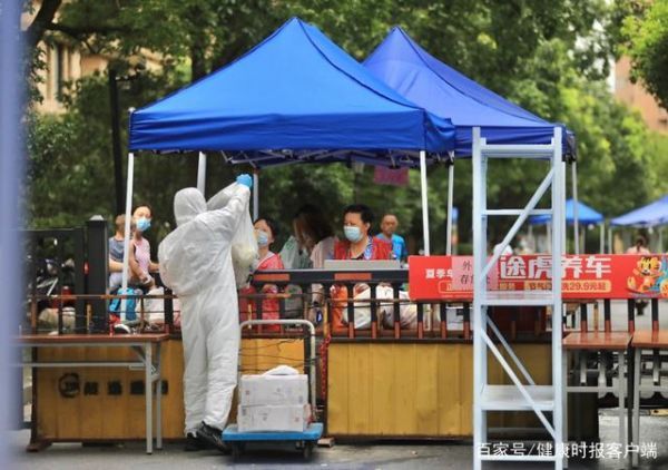 工作人员和志愿者为隔离小区居民送上外卖的餐饮,保障物资供应。文汇报记者袁婧摄