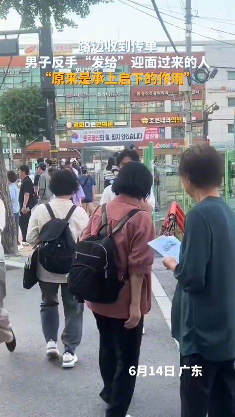 路边收到传单,男子反手“发给”迎面过来的人,“原来是承上启下的作用”