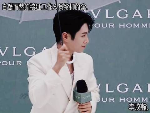 骨子里的温柔与教养,让他自然而然地从工作人员手中接过伞!