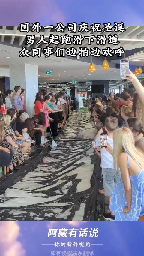 国外一公司庆祝圣诞，男人起跑滑下滑道，众同事们边拍边欢呼！