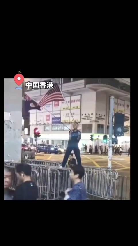 一男子在香港街头高举挥舞英美国旗,被愤怒的市民一脚踹倒