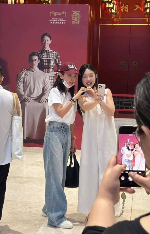李冰冰管乐在展板前比心自拍。