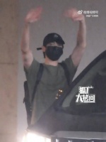 到达上海，雨中举双手和粉丝挥手打招呼