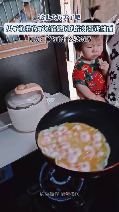 男子抱娃单手给虾蛋饼翻面引关注