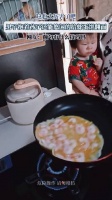 男子抱娃单手给虾蛋饼翻面引关注