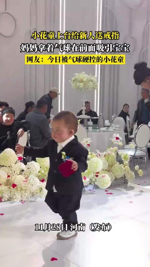 小花童上台给新人送戒指，妈妈拿着气球在前面吸引宝宝