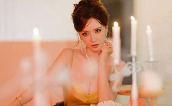 张萌托腮浅笑，烛光下神态温婉动人。