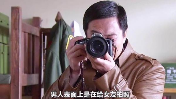 男人假装给女友拍照，实际上是在拍墙上的边境布防图