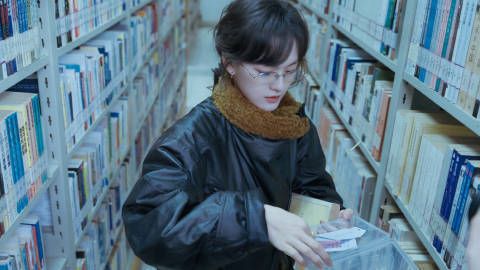 文淇穿黑色皮衣搭配黄色围巾。