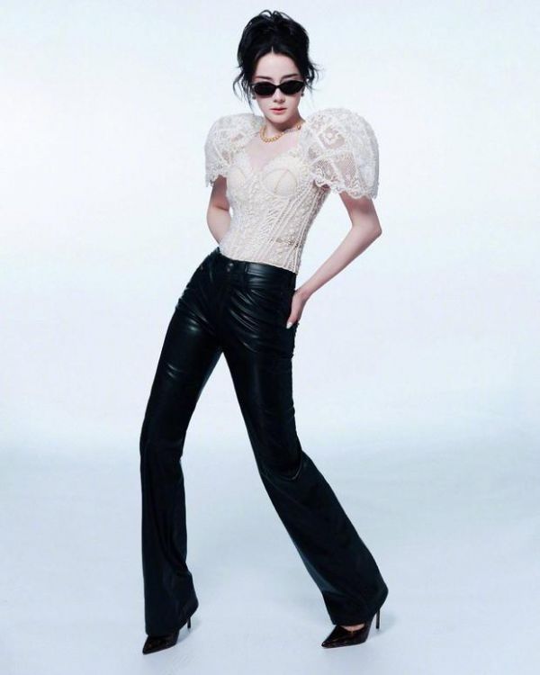 迪丽热巴白蕾丝泡泡袖上衣搭配黑皮裤与墨镜,双手插兜,酷飒气场拉满。