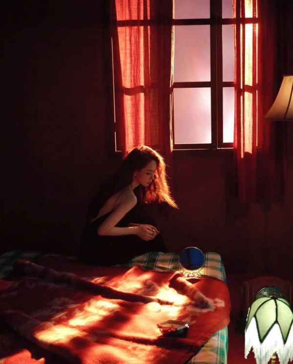 戚薇窗边静坐，逆光勾勒清冷氛围感。