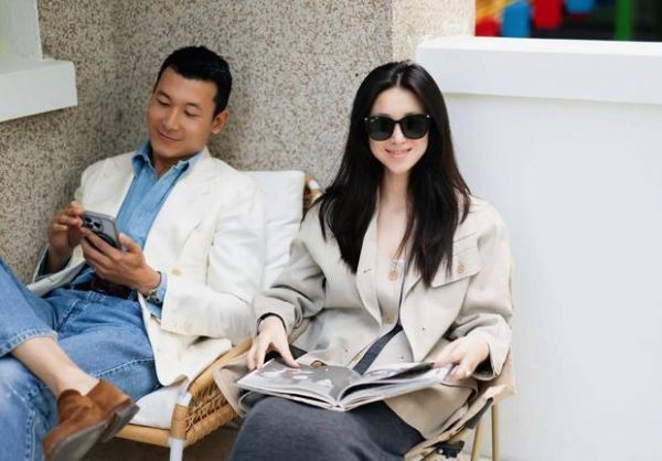 朱珠翻书浅笑，整体氛围慵懒惬意。