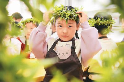 4月1日,河北省邯郸市广平县第四幼儿园的小朋友在体验戴柳帽民俗。程学虎摄(人民视觉)