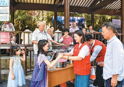 近日,浙江省金华市公交集团营运二公司的志愿者在金华市双龙风景旅游区公交站,为乘车的游客送上一杯杯清热消暑的凉茶。 李建林摄(人民视觉)