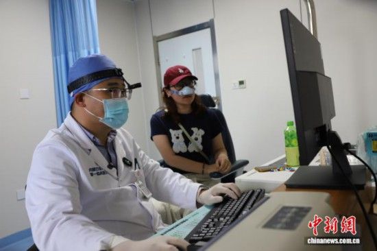 图为王博谦为患者讲解注意事项。 中新网记者 张林虎 摄