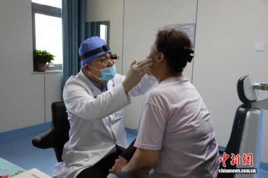图为王博谦为患者进行检查。 中新网记者 张林虎 摄