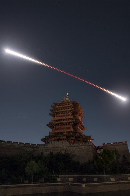 2025年9月7日夜晚至8日凌晨，在山西大同古城墙乾楼拍摄的月全食轨迹（多张堆栈），形似“金箍棒”。新华社发（韩享 摄）
